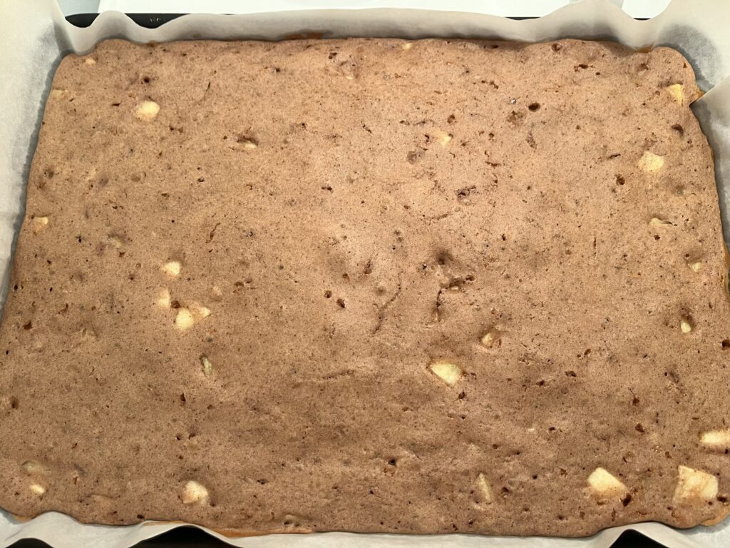 Apple pancakes fresh out of the oven, in a baking sheet, before slicing.