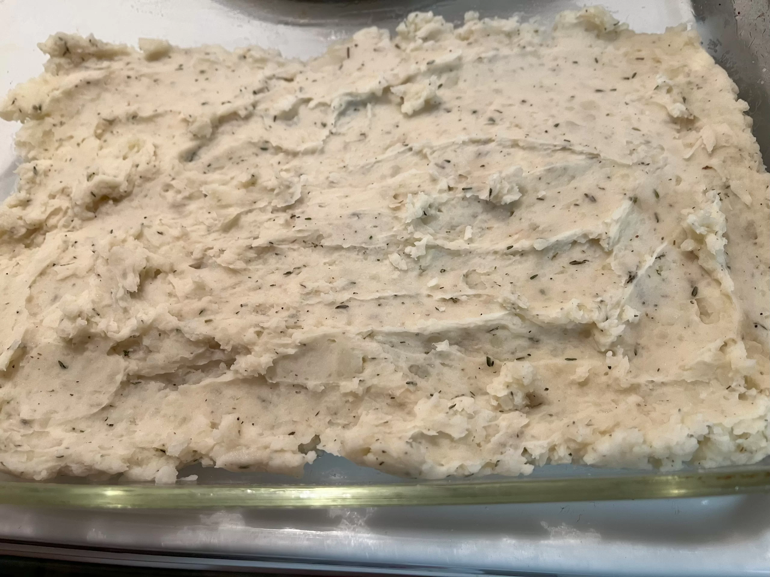 Mashed potatoes in a glass dish.