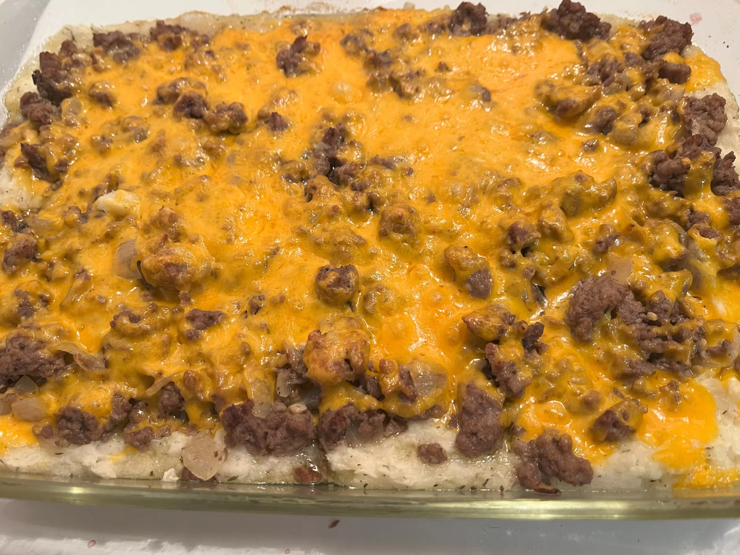 Melted cheese on beef, onions, garlic, and mashed potatoes.