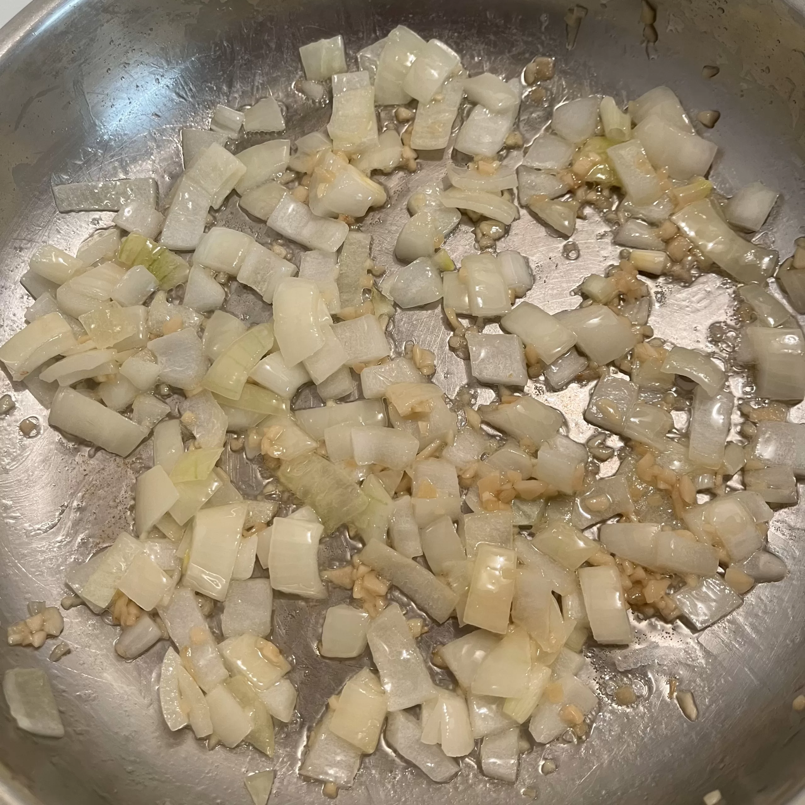 Onions and garlic cooking in a pan.