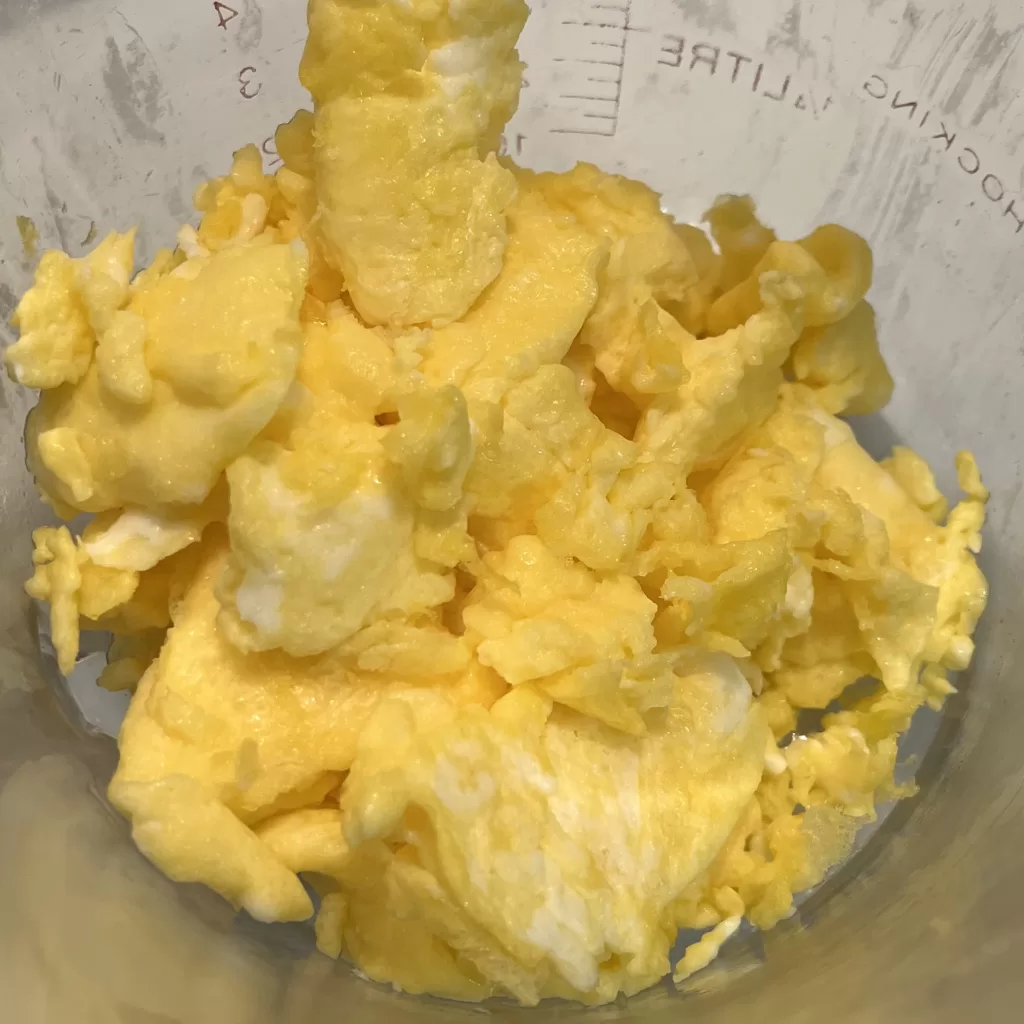 Scrambled eggs in a glass measuring cup.