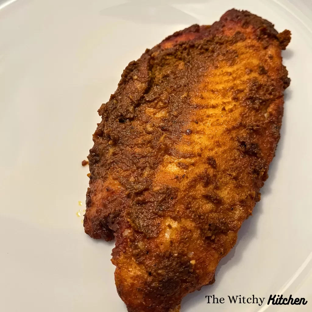 Seasoned and cooked Basa fish on a white plate.