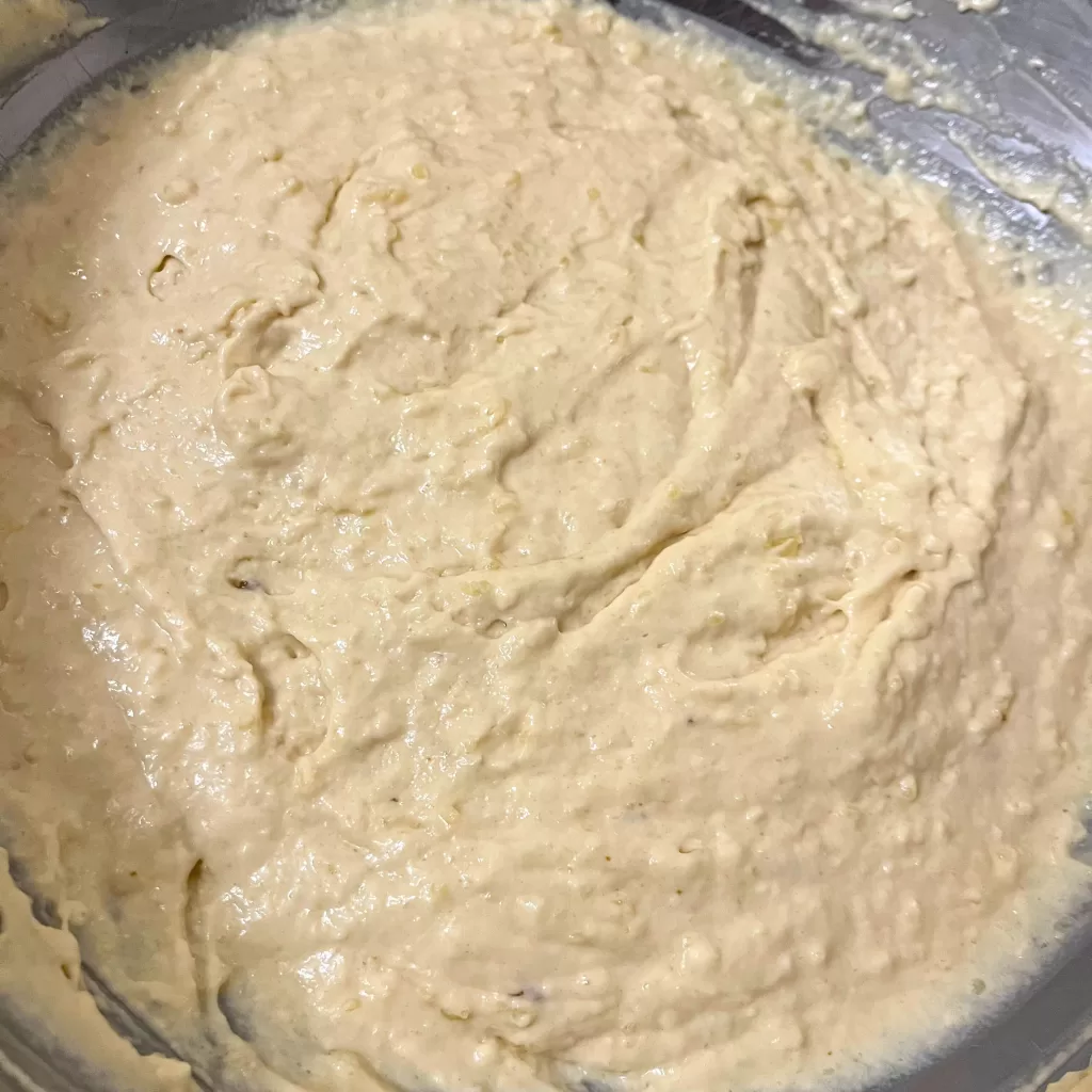 Pancake batter in a large metal mixing bowl.