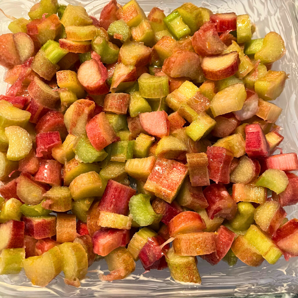 Rhubarb pieces in a greased clear glass baking dish.